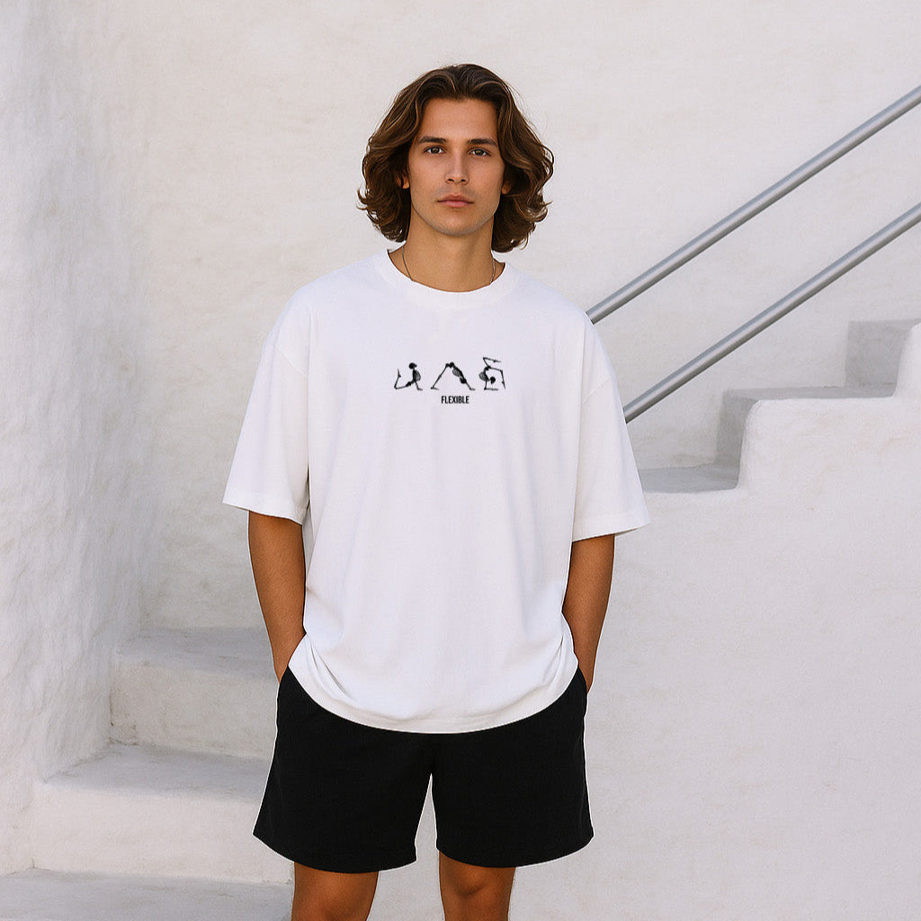 Man wearing a white t-shirt with a logo and black shorts standing on a staircase.